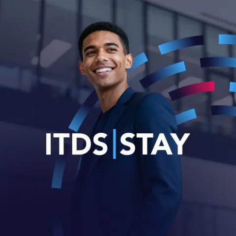Een lachende man in een pak met de tekst "ITDS | STAY" en kleurvolle strepen op de achtergrond.